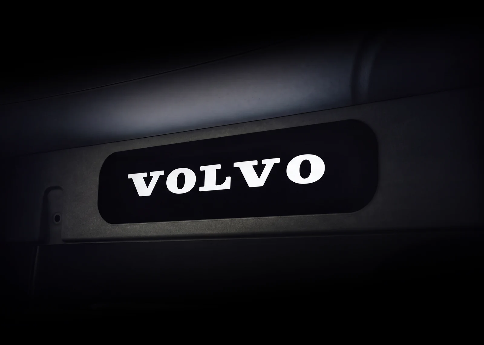 Illuminated VOLVO wordmark sign mounted on the cab rear wall